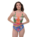 Model wearing a sleeveless one-piece swimsuit from the Portofino Collection, featuring a coastal print with blue and peach tones, standing against a white background.